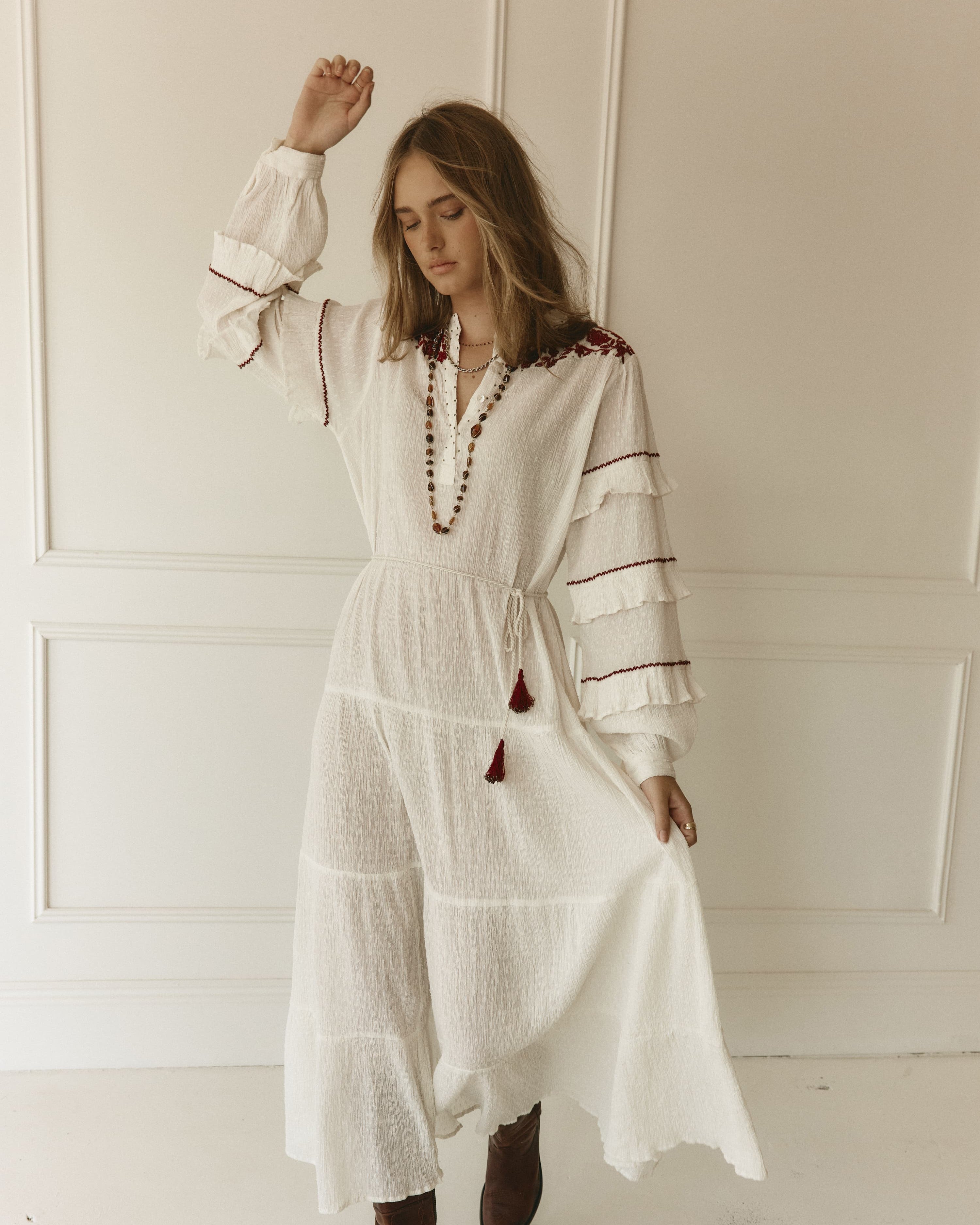 Lakoen Anais Dress in white cotton dobby with floral embroidery in burgundy and frilled bishop sleeves