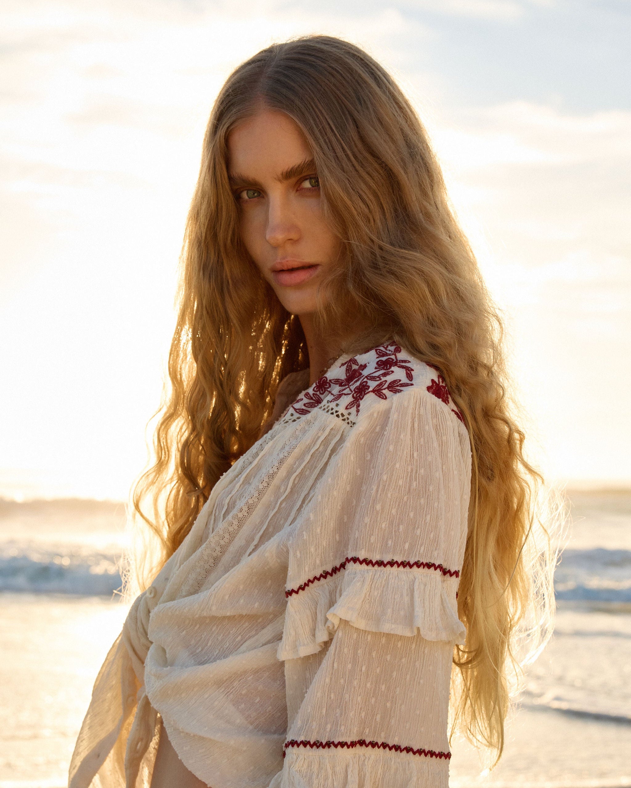 Lakoen Anais Blouse in white soft cotton with lace insets, ruffled bishop sleeves, shirring and burgundy embroidery
- hand-crafted - hand-embroidered - bohemian - slow luxury - ethically made - natural fibres