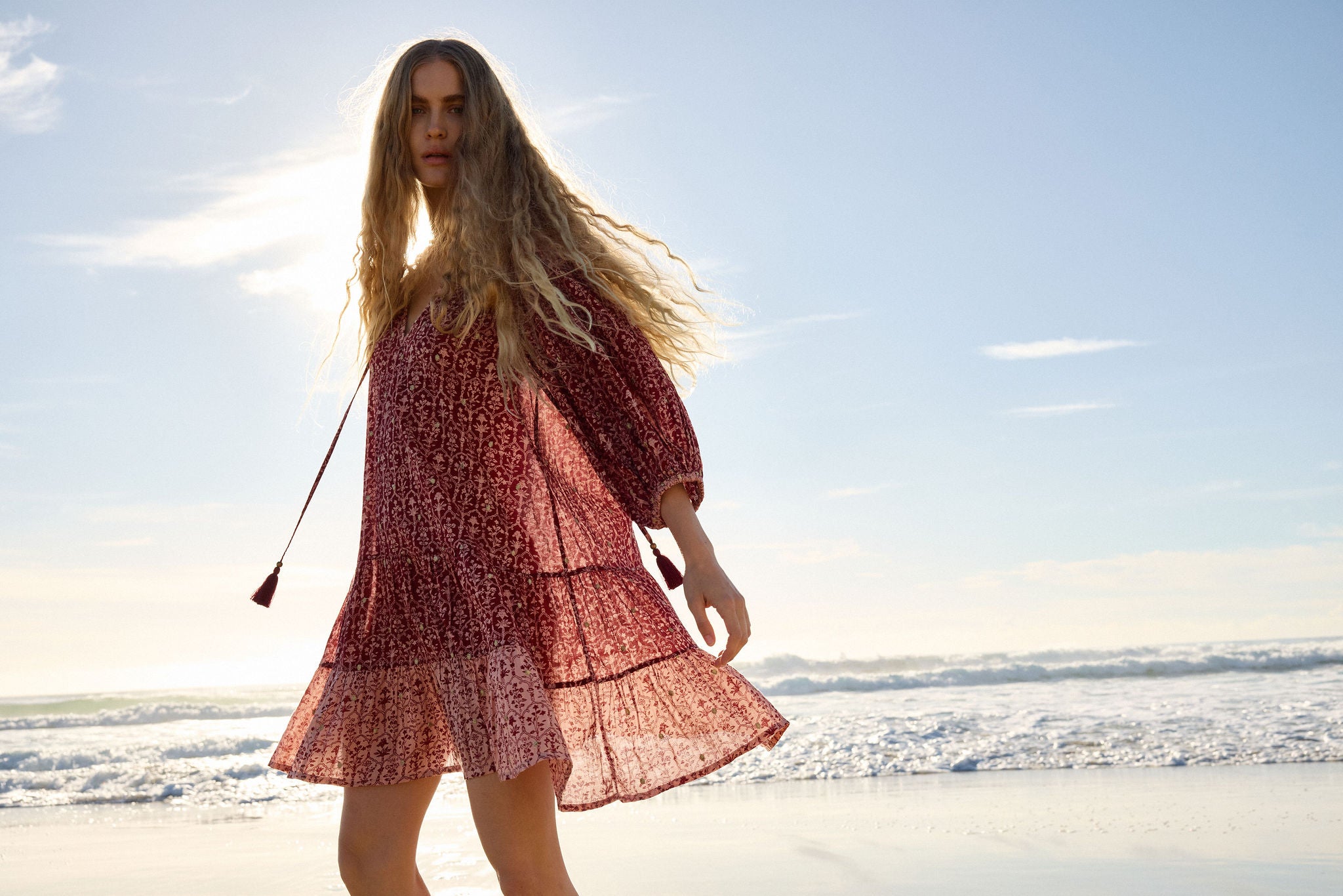 Lakoen model wears our Emile Short dress, floating as she turns in the sunlight infront of the ocean. The Emilie is crafted from soft printed cotton, in rose pink & merlot hues, with delicate gold lurex embroidered dots - slow fashion - hand-crafted - ethically made