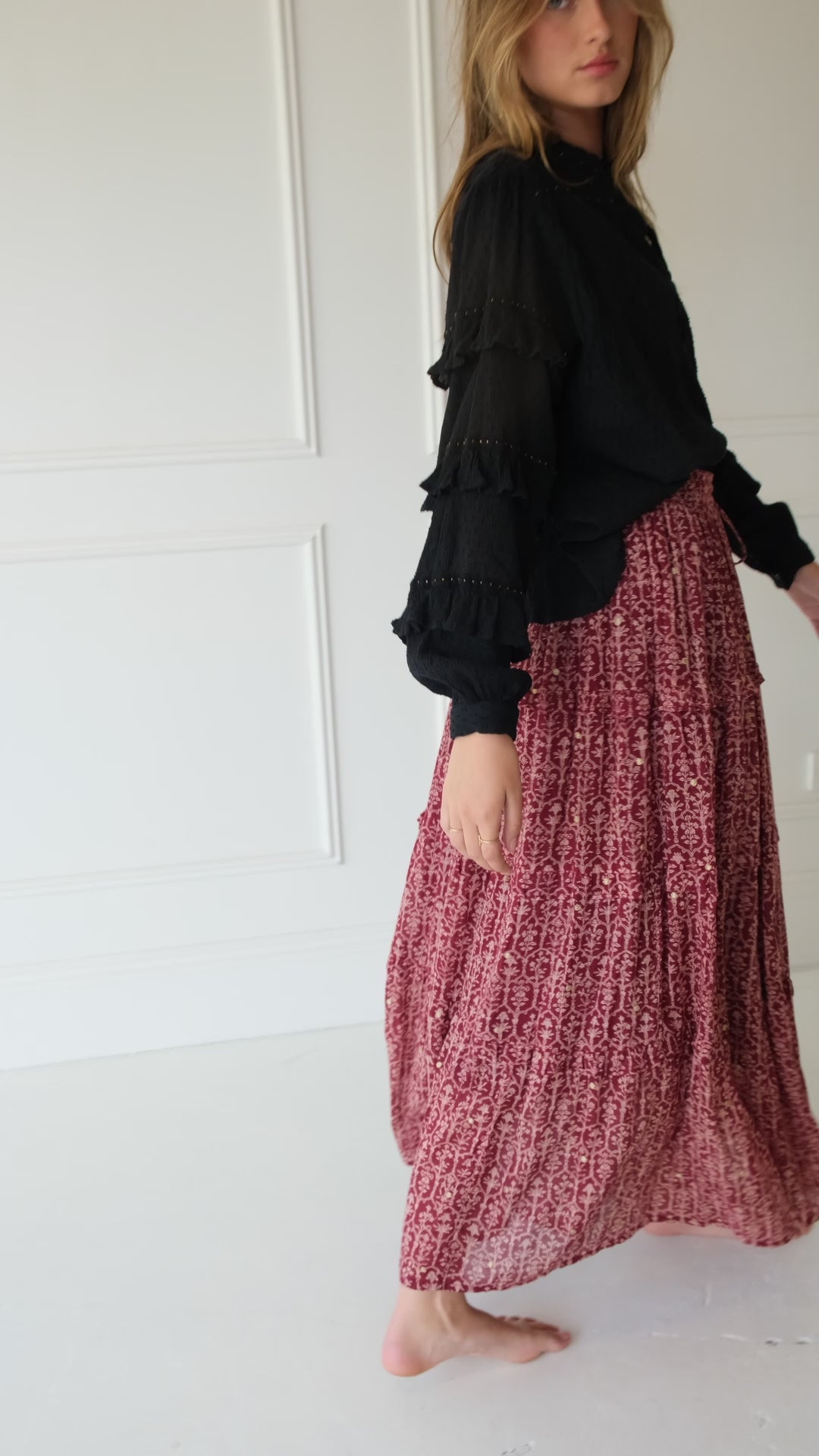 Lakoen Anais Blouse in black soft cotton with lace insets, ruffled bishop sleeves, shirring and tonal embroidery. Paired with our Emile Maxi Skirt,Crafted from fine cotton with a delicate block-inspired print in rose and rich burgundy hues, adorned with shimmering gold embroidered dots. - slow-luxury - hand-crafted - bohemian - ethically-made