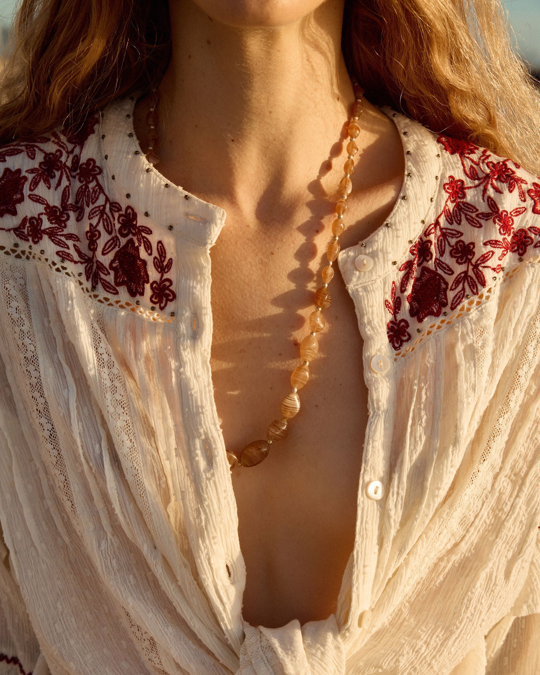 Lakoen Anais Blouse in white soft cotton with lace insets, ruffled bishop sleeves, shirring and burgundy embroidery