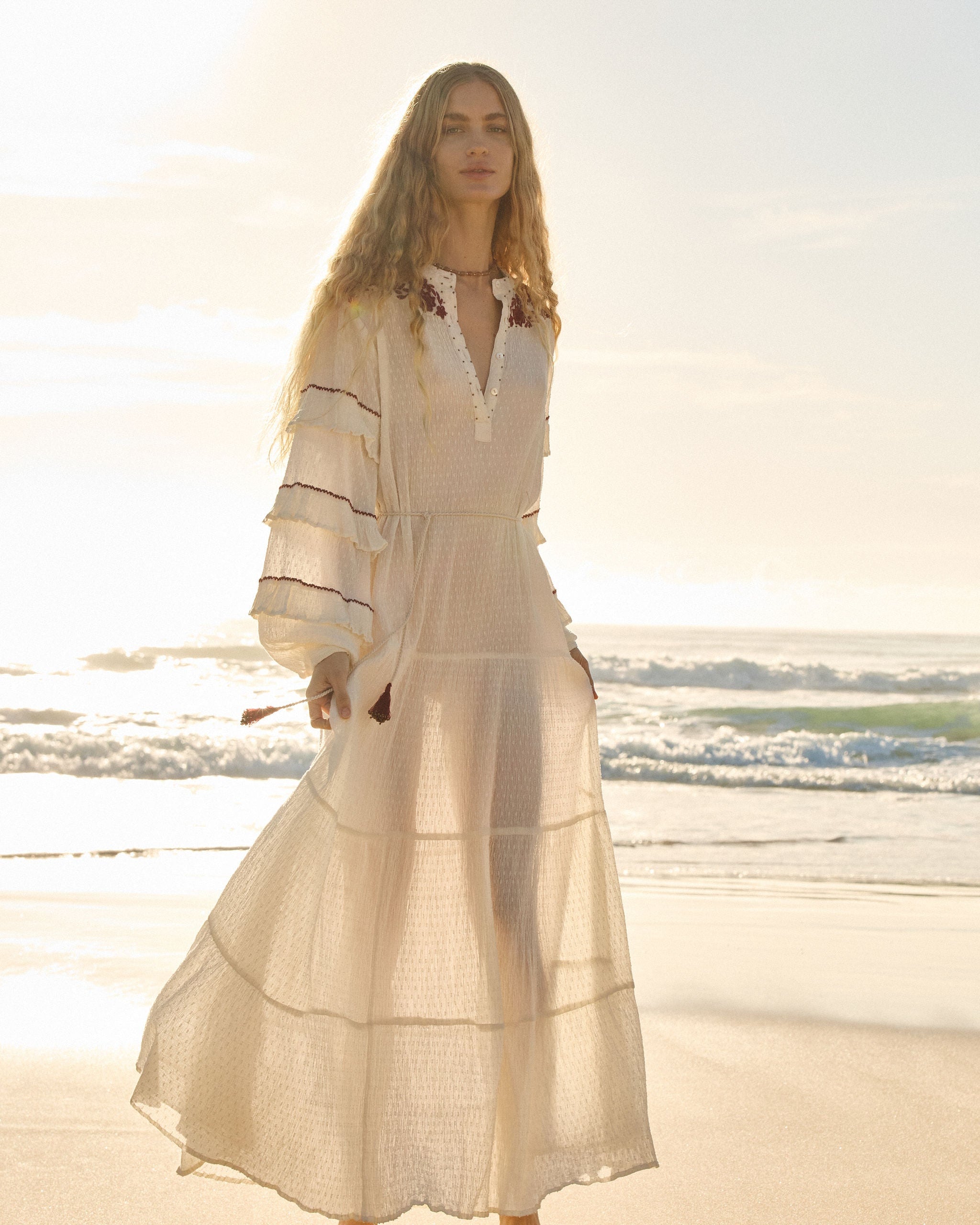 Lakoen Anais Dress in white cotton dobby with floral embroidery in burgundy and frilled bishop sleeves